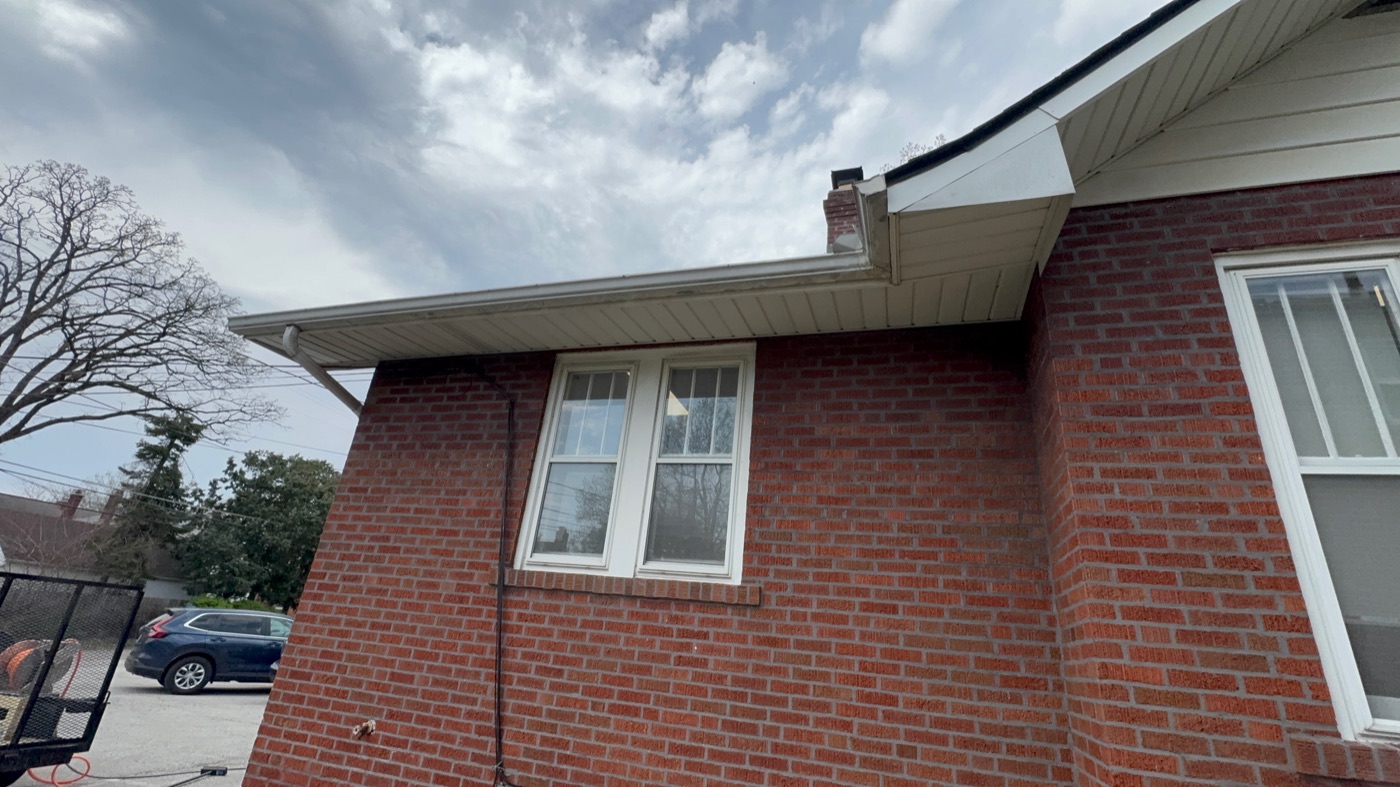 White gutters and soffit brightened on a brick home
